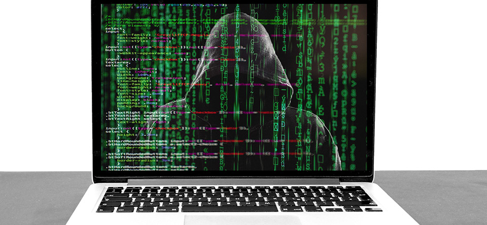 Silhouette of hacker in a hoodie hiding behind Matrix rain computer code