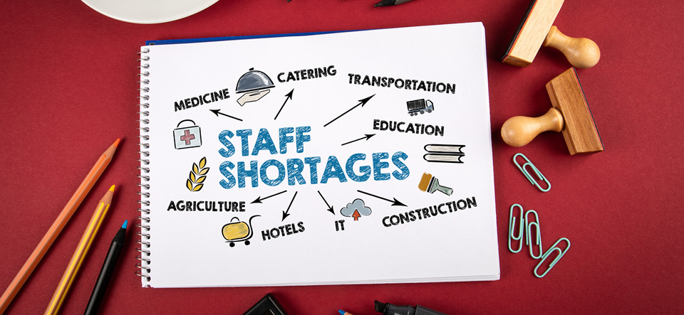 Staff Shortages, business, jobseeker and employer concept. Office supplies on a red table.