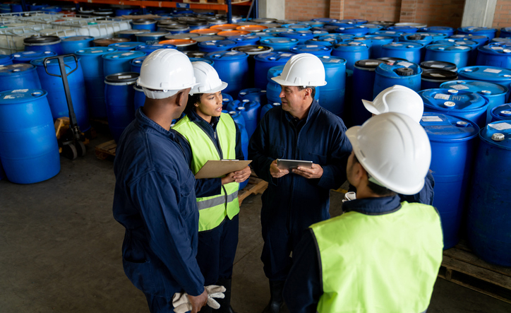 Group of Latin American workers talking in a meeting at a chemical plant – teamwork concepts