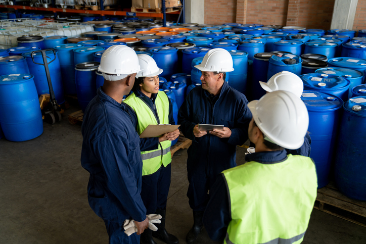 Group of Latin American workers talking in a meeting at a chemical plant – teamwork concepts