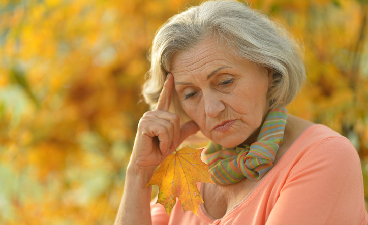 Nice sad old woman on the autumn background