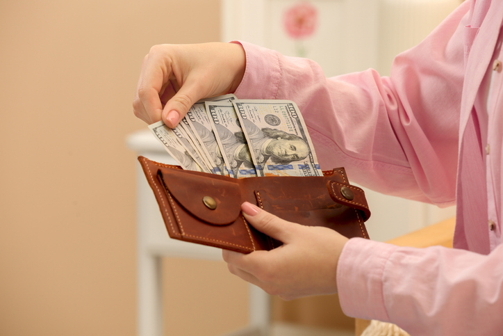 Woman counting dollar bills indoors, closeup with space for text. Money exchange