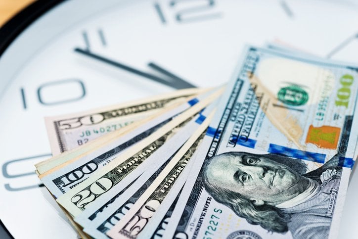 Dollar bills on top of a clock face